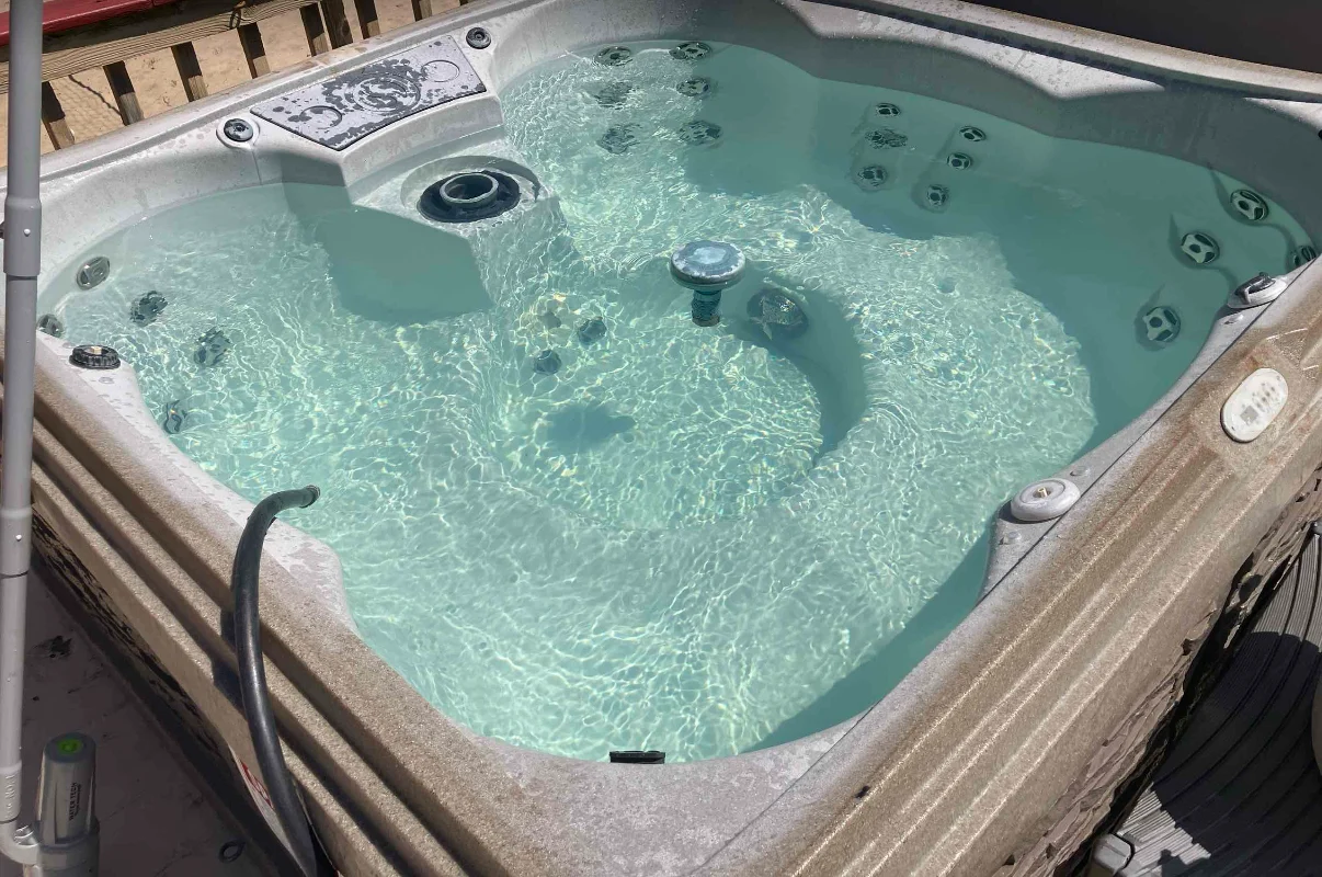 Outdoor hot tub with circulating water beside a wood deck