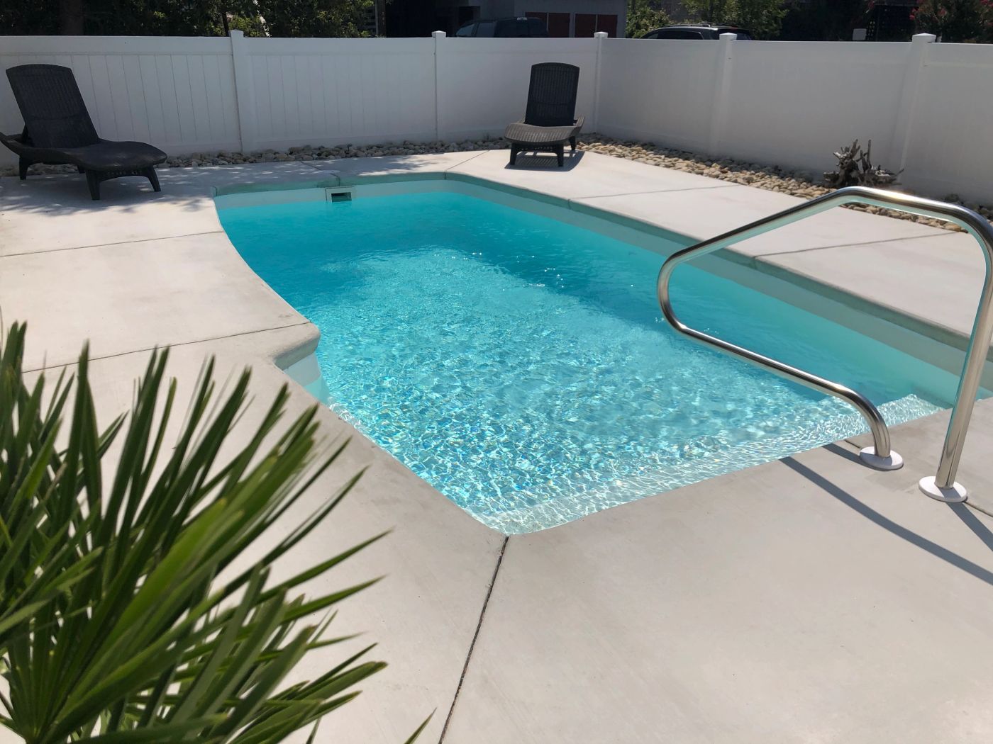 Clear water and handrail in a sunlit pool setting